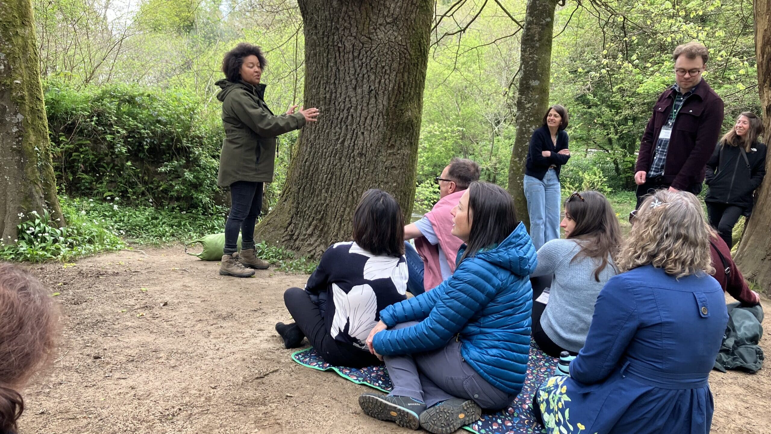 Beth Collier talks to the Leadership college fellows by the river bank.