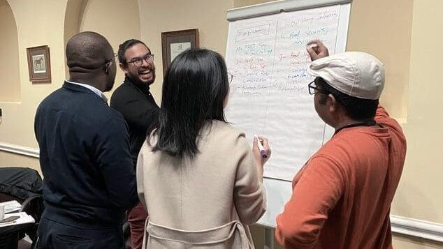 Delegates at an ACCESS Summer School writing on a board