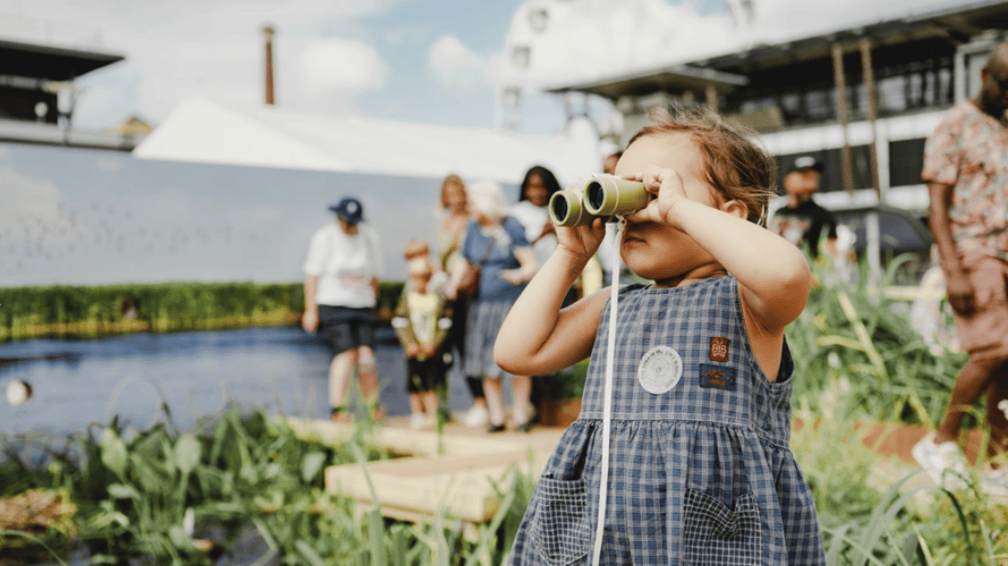 Image of small white child looking through binoculars